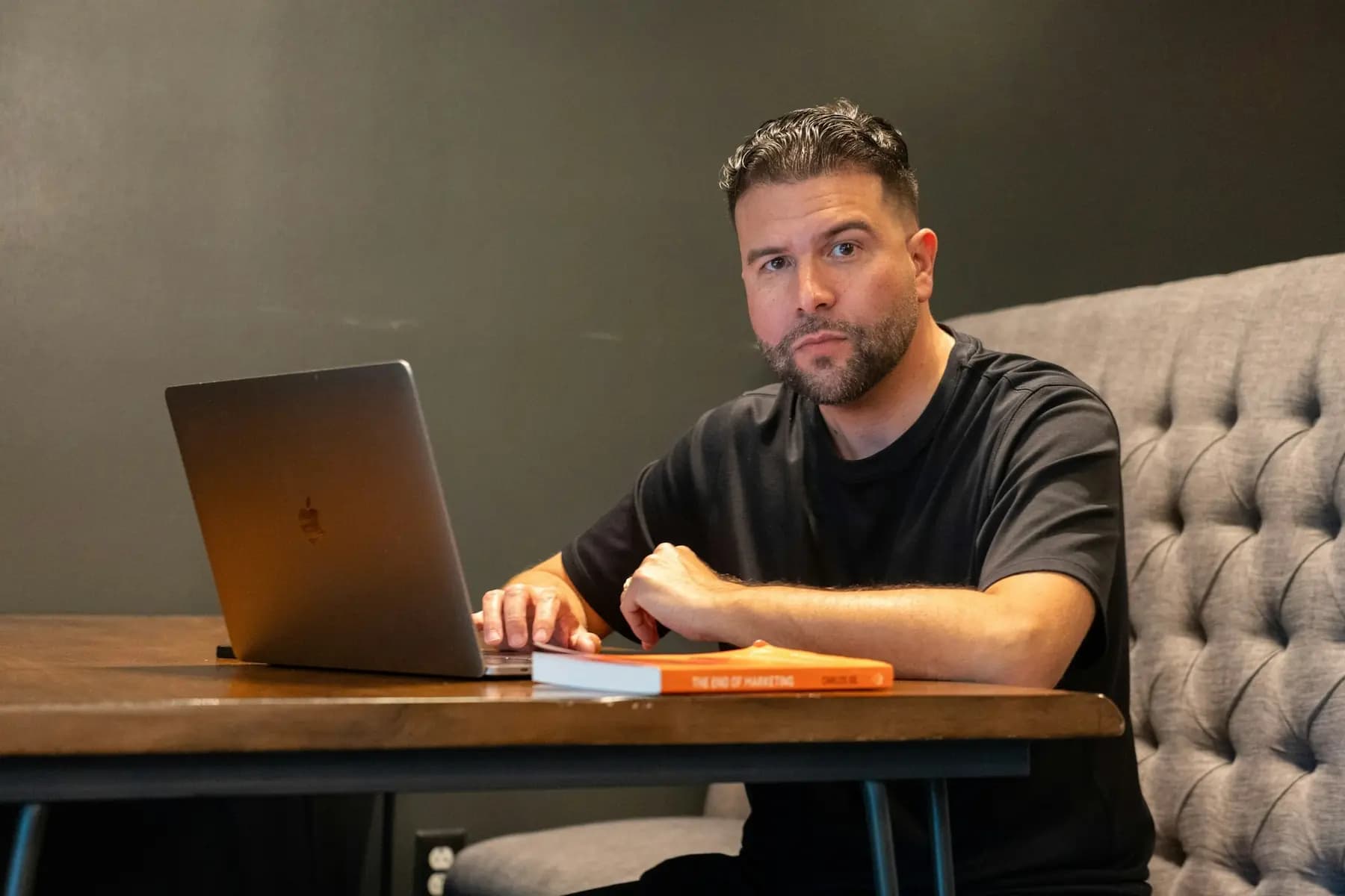 A business owner working on a laptop at a wooden table